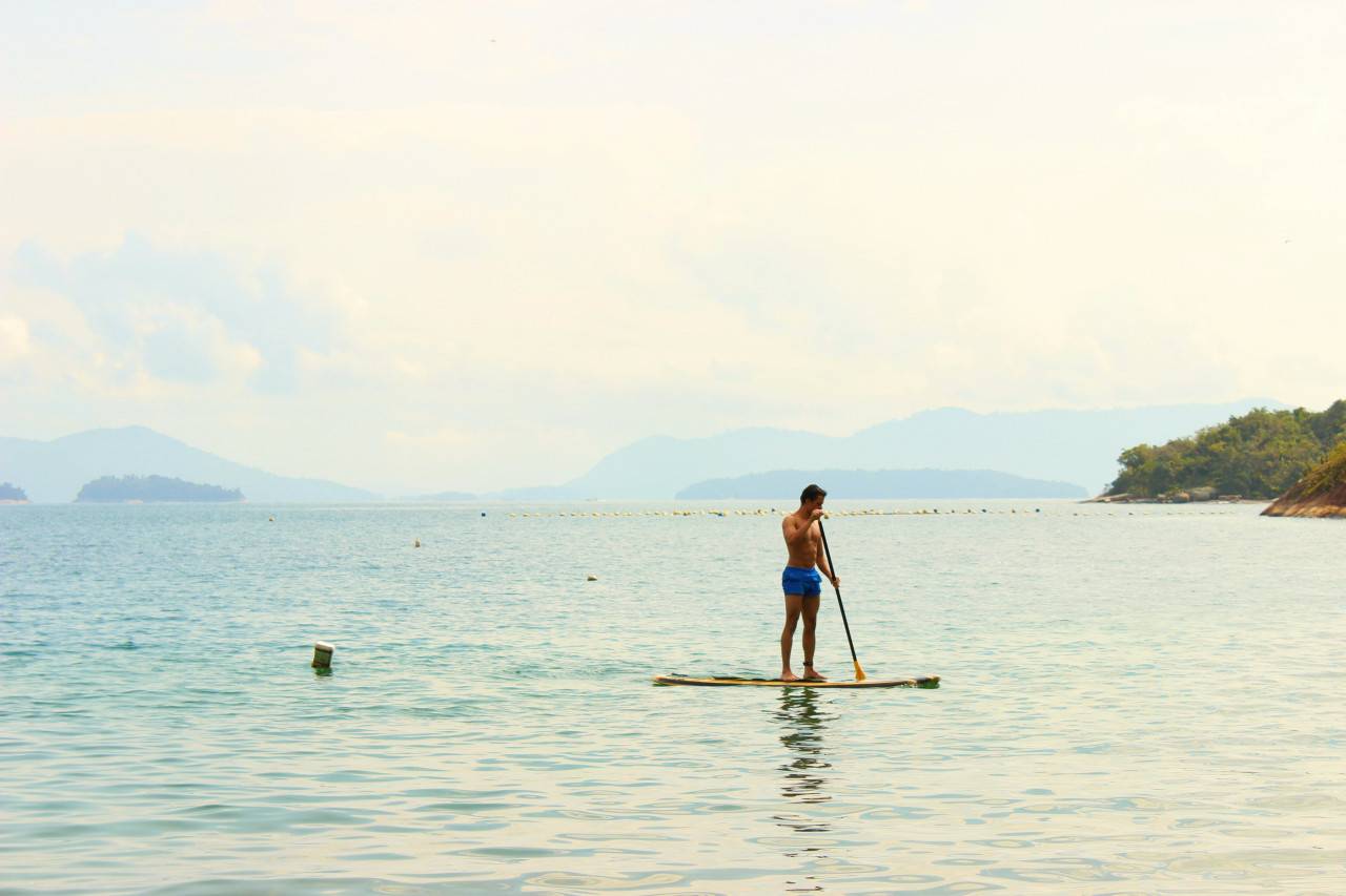 Mann mit SUP auf See
